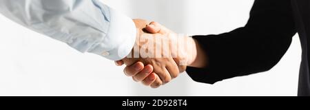 Beschnittene Ansicht von Politikern, die die Hände auf weißem Banner schütteln Stockfoto