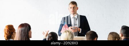 Ernster politischer Agitator, der mit den Wählern im Konferenzsaal spricht, Banner Stockfoto