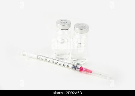 Zwei Fläschchen mit Medizin und Spritze zur Injektionsbehandlung. Covid-19 Impfstoffkonzept. Isoliert auf weißem Hintergrund Stockfoto