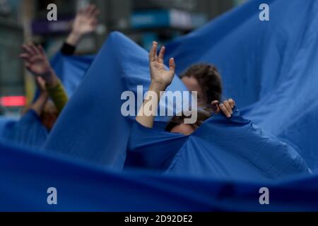 Madrid, Spanien; 02/11/2020.- Bewegung gegen das Aussterben der Klimakrise Rebellion (XR) hat heute die Gran Vía von Madrid mit einer Menschenflut besetzt, um die wachsende Zahl von Menschen, die von dem Anstieg des Meeresspiegels infolge der ökologischen Notlage betroffen sind, sichtbar zu machen.Sie sind inspiriert von der Arbeit «divisor», Von der brasilianischen Künstlerin Lygia Pape, um eine auffällige zivile Ungehorsam Aktion zu erreichen. Etwa dreißig Menschen marschieren unter einer 150 Quadratmeter großen Leinwand "Wir sind mit Wasser bis zum Hals", sagen sie aus der Bewegung sie darauf hinweisen, dass die Zahl der Klima Vertriebenen lag bei 25 Millionen im Jahr 2019, und t Stockfoto