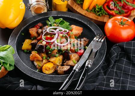 Georgischer Salat mit Fleisch auf schwarzem Hintergrund Stockfoto