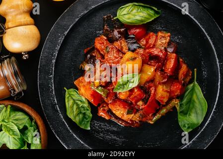 Georgischer Salat mit Fleisch auf schwarzem Hintergrund Stockfoto