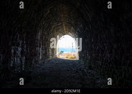 Verlassen Sie den dunklen Eisenbahntunnel. Verlassen Sie den dunklen Eisenbahntunnel. Ein Licht am Ende eines Tunnels. Stockfoto