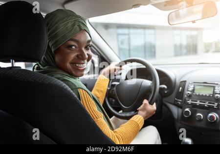 Kauf Von Automobile. Lächelnd Schwarz Muslimische Dame In Hijab Testen Neues Auto Stockfoto