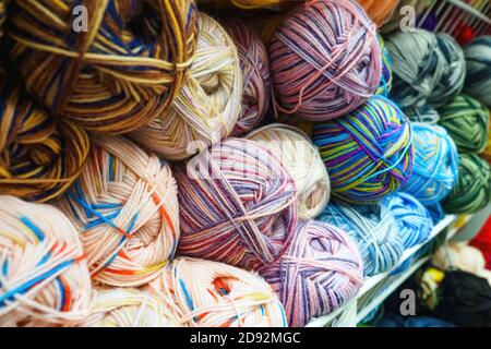 Blick auf verschiedene Farbverwicklungen von Wollgarn zum Stricken, selektiver Fokus. Stockfoto