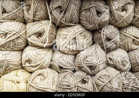 Hintergrund aus Wollgarn, Bälle zum Stricken, beige Fäden aus Naturwolle. Stockfoto