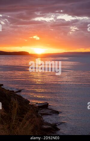 Kea, Insel Tzia, Reiseziel Griechenland. Sonnenuntergang, Sonnenaufgang orange durch Wolken über mediterranem Meeresgrund. Die Sonne spiegelt sich auf dem Wasser Stockfoto