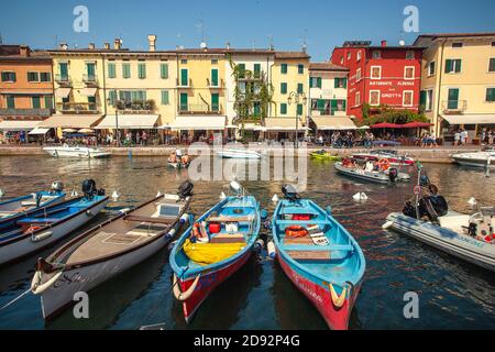 LAZISE, ITALIEN 16 SEPTEMBER 2020: Dogana Veneta und Porticciolo in Lazise, in Italien mit farbigen Booten Stockfoto