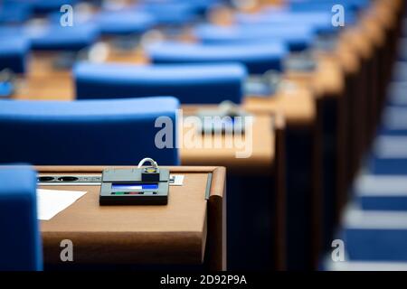 In einem leeren parlamentsgebäude. Blaue Stühle in Übereinstimmung mit Abstimmmaschinen für jeden Sitz auf dem Schreibtisch. Stockfoto