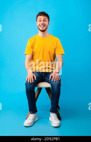 Porträt eines hübschen jungen Mannes auf dem Stuhl sitzen Stockfoto