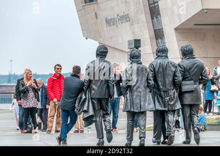 Rückansicht der Personen, die ihr Foto mit der Statue der Beatles am Liverpool Pier Head aufgenommen haben. Stockfoto