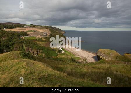 Blick auf die Küste von Berriedale Estate Cottages und Strand. Auch die Erdarbeiten für die Neuausrichtung der A9 an der Haarnadel auf der Berriedale Braes. Stockfoto