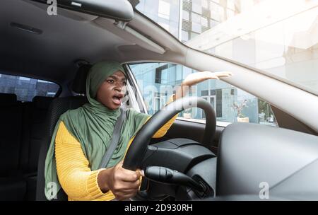 Trafic Stress. Verärgerte Schwarze Muslimische Frau Beschwert Sich Über Etwas Beim Autofahren Stockfoto