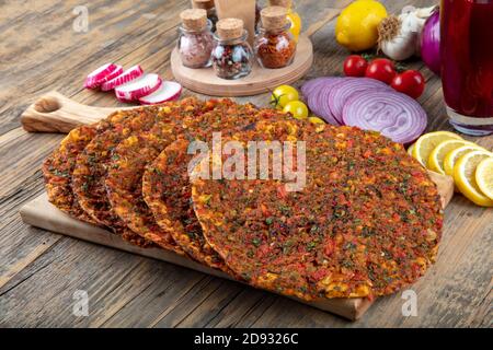 Traditionelle türkische Speisen; Lahmacun (türkische Pizza). Lahmacun traditionelle türkische Pizza und Wraps mit Salat isoliert auf rustikalen Holztisch Stockfoto