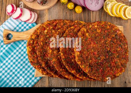 Traditionelle türkische Speisen; Lahmacun (türkische Pizza). Lahmacun traditionelle türkische Pizza und Wraps mit Salat isoliert auf rustikalen Holztisch Stockfoto