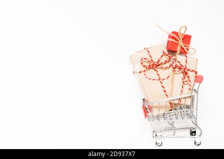 Warenkorb mit Geschenken auf weihnachtlichen weißen Hintergrund mit Kopierplatz. Stockfoto