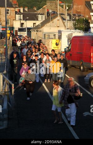 Largs, Ayrshire, Schottland, Fußpassagiere steigen an Bord der Caledonain MacBrayne Ferry für die schottische Insel Cumbrae in der Sommerabendsonne Stockfoto