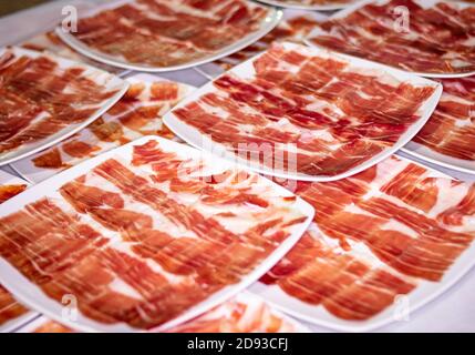 Catering-Service. Gerichte und Portionen iberischer Schinken und Serrano-Schinken bei einer gesellschaftlichen Veranstaltung Stockfoto