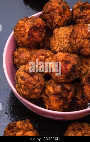 Rosa Schüssel mit gebratenen Fleischbällchen mit Gewürzen. Hausgemachte Speisen. Stockfoto