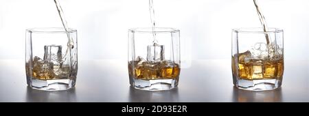 Set von isolierten Aufnahmen von Whiskey mit Spritzer auf weißem Hintergrund. Whiskey in ein Glas mit Eis gegossen Stockfoto