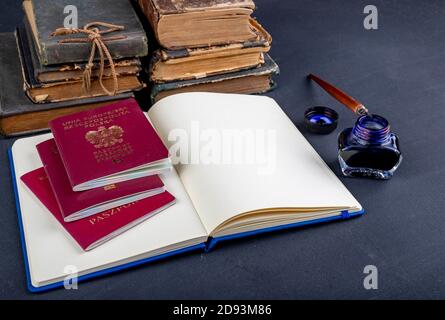 Handschellen, Reisepass und Notizbuch auf dem Tisch. Zubehör auf dem Schreibtisch auf der Polizeistation. Dunkler Hintergrund. Stockfoto