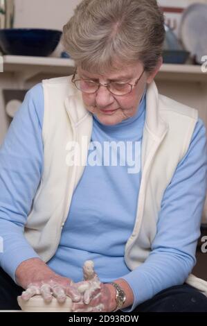 Eine Töpferin arbeitet am Töpferrad. Foto von Liz Roll Stockfoto