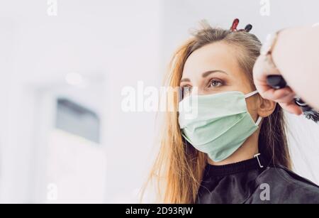 Friseur und Kunden waring Gesichtsmaske während Pandemie Stockfoto