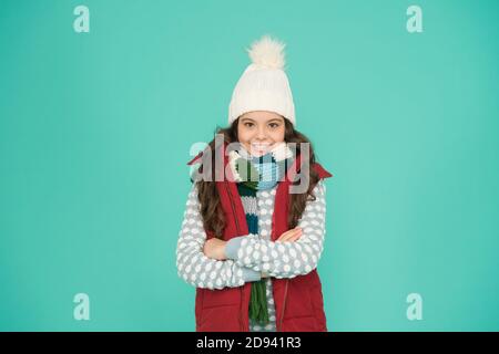 Vorbereitung für den Winter. Winter Kid Mode. Kind mit langen lockigen Haaren in gestrickten Hut. Kalte Jahreszeit Stil weihnachtsaktivität. Kindheit Glück. Thermische Kleidung. Happy teen Mädchen tragen warme Kleidung. Stockfoto