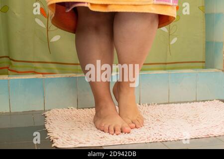Frau, die aus der Dusche kommt - Detail von kurvig Frauenbeine Stockfoto