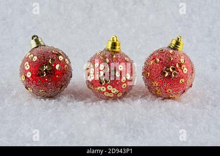 Rote Weihnachtskugeln auf etwas Schnee Stockfoto