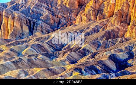 Schroffe Felsformationen bei Sonnenuntergang schaffen eine bunte Landschaft Zabriskie Point Stockfoto