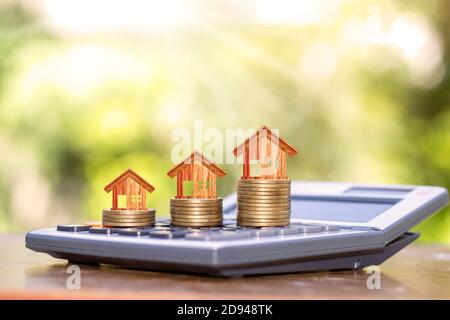 Holzhaus-Designs auf Münzen, einschließlich Immobilien-Investitionen Ideen-Rechner. Stockfoto