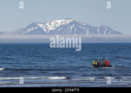 Zodiac Gummiboot voller Ökotouristen, vom Strand der Insel Onekotan gesehen, Kurilkette, Ochotsker See, Russland 5. Juni 2012 Stockfoto