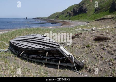 Umgedrehtes Boot am Strand auf der Insel Urup, Kurilkette, Ochotsker See, Russland 5. Juni 2012 Stockfoto