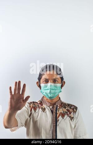 Potrait von asiatischen Mann zeigt Geste stoppen. Asiatischer Mann trägt chirurgische Maske gegen ansteckende Viren zu schützen und vor allen Verschmutzungen zu schützen Stockfoto