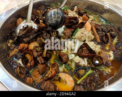 Frisch geschmorte Meeresfrüchte mit getrocknetem Pfeffer in der würzigen Suppe, einschließlich Garnelen, Oktopus Stockfoto