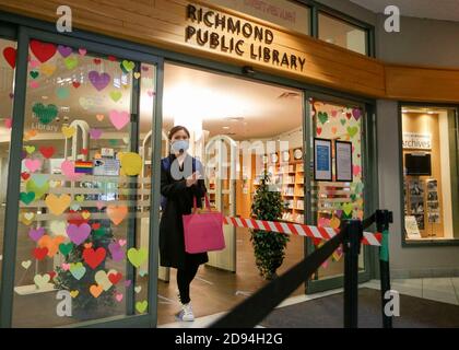Richmond, Kanada. November 2020. Eine Frau mit Gesichtsmaske kommt aus der Richmond Public Library in Richmond, British Columbia, Kanada, 2. November 2020. Einige kanadische Provinzen erwägen strengere Maßnahmen, da die zweite Welle von COVID-19 im Land wütet. Kanada meldete insgesamt 239,143 COVID-19 Fälle und 10,202 Todesfälle am Montagnachmittag, so CTV. Quelle: Liang Sen/Xinhua/Alamy Live News Stockfoto