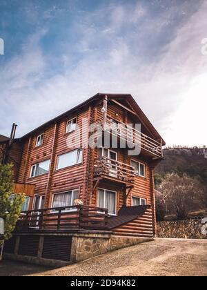 Schönes Holzland Traumhaus mit Kunststofffenstern. Vorderansicht mit einem wunderschönen Sonnenuntergang Stockfoto