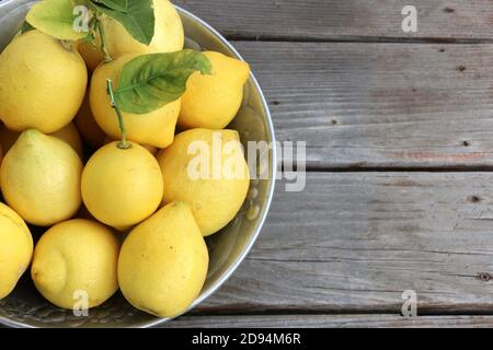Silberne Schale mit schönen, leuchtend gelben Zitronen, in Kalifornien selbst gezüchten. Stockfoto