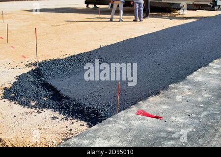 Legen frischen Asphalt auf der Straße. Bau der Straße, Schotterbasis. Selektiver Fokus. Stockfoto