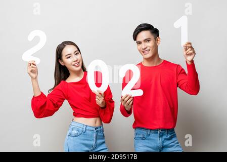 Happy Asian paar lächelnd und zeigt Nummer 2021 für neue Jahreskonzept Stockfoto