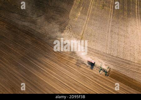 Luftaufnahme. Feld Für Das Pflügen Des Traktors. Beginn Der Landwirtschaftlichen Frühjahrssaison. Grubber gezogen von EINEM Traktor auf dem Land ländliche Feldlandschaft. Staub Stockfoto