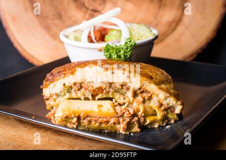 Portion Greak Moussaka mit Salat und Garnierung Stockfoto