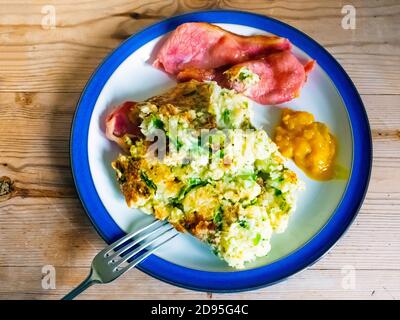 Bubble und Squeak ein traditionelles Gericht von links über gemacht Kartoffeln und Gemüse hier serviert mit knackigem gebratenem Speck und Piccalli Senf Gurke auf a b Stockfoto