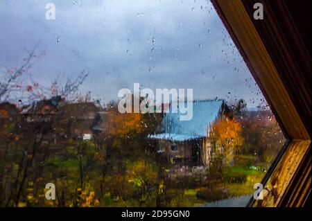 Herbst im Garten.Blick durch Fenster mit Regentropfen bedeckt In den Herbstgarten Stockfoto