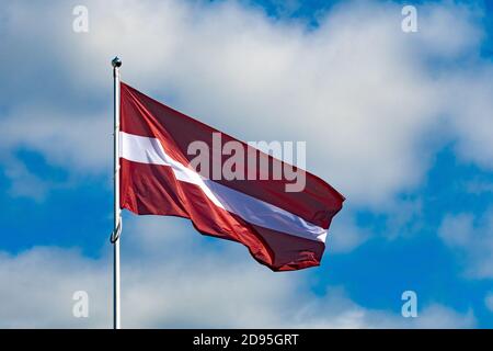 Lettische Flagge winkt am Himmel, Baltische Länder, vereint, unabhängig, Grenzen, Baltische Blase Stockfoto