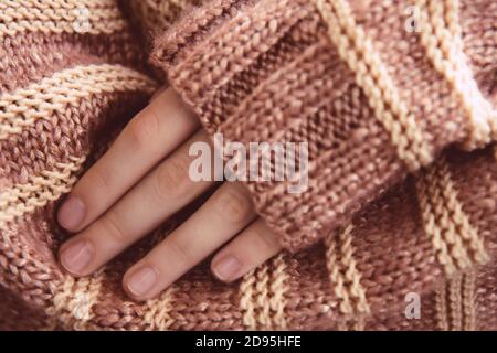 Frau in einem beige weichen warmen Strickpullover faltete ihre Arme. Bald Herbst Stockfoto