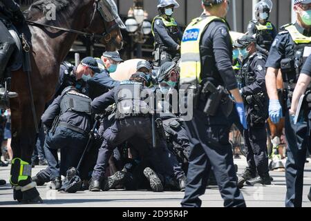 Melbourne, Australien, 03. November 2020, Eine Gruppe von Polizisten kämpft mit einem Mann auf dem Boden, während sie versuchen, ihn mit Handschellen zu fesseln, nachdem sie letzte Maßnahmen ergriffen haben, um den Protest zu beenden und alle Demonstranten im Landtagsparlament während einer weiteren Freedom Day Demonstration am Melbourne Cup Day mit der Forderung nach der Plünderung von Premier Daniel Andrews zu beschießen Über Lockdown Gesetze. Kredit: Michael Currie/Alamy Live Nachrichten Stockfoto