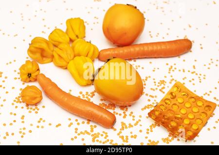 Stärkung des Immunsystems mit natürlichen Quellen von Vitaminen und Mikroelementen, Vitamin C. Foto Gemüse und Obst mit Tabletten. Orange Stimmung Stockfoto