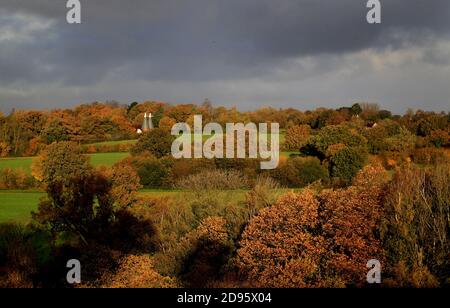 Ein Haus in der Nähe von Hawkhurst in Kent, umgeben von Herbstfarben in der Morgensonne. Die Weidenhäuser sind ein besonderes Merkmal der Landschaft von Kent und Sussex und wurden ursprünglich zum Trocknen des geernteten reifen Hopfens gebaut, der als Zutat beim Bierbrauen verwendet wurde. Stockfoto